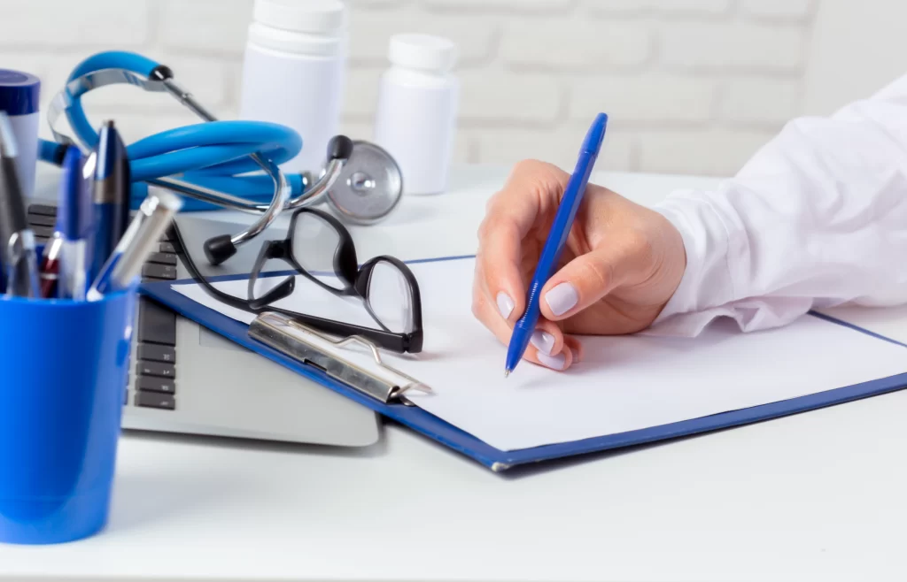 A physician writing the list of medications